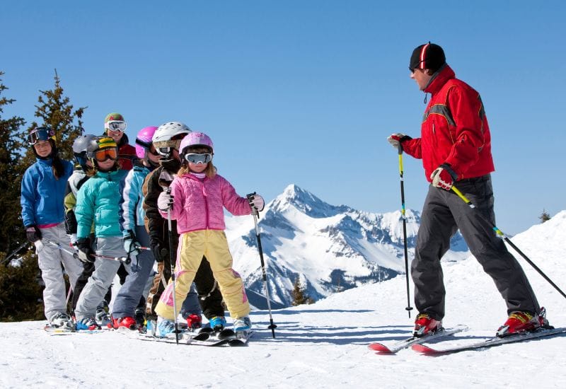 clase grupal esquí de niños con su profesor de esquí