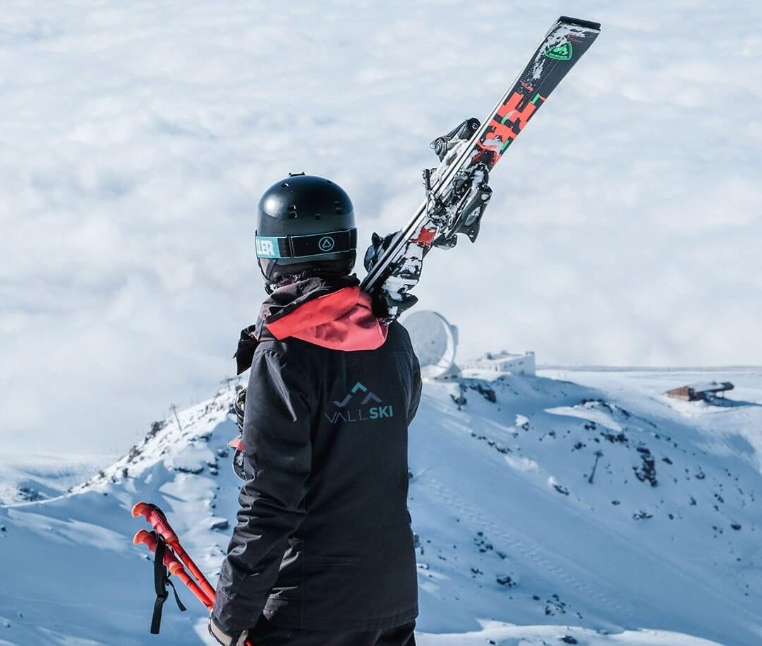 monitor de esquí adminarando sierra nevada con el observatorio de fondo